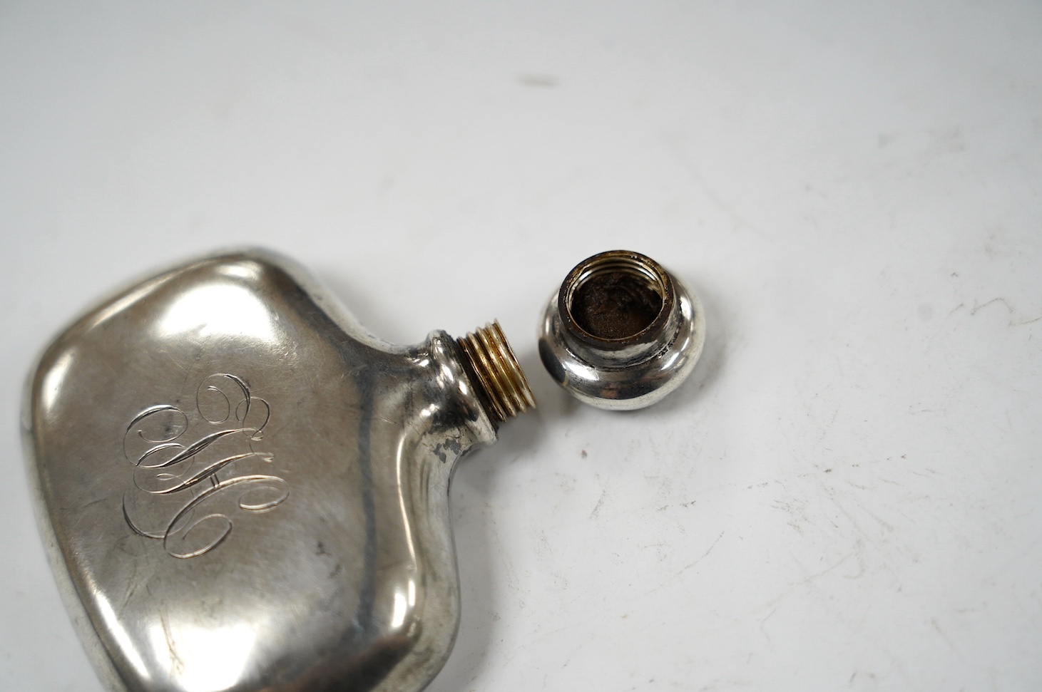 A late Victorian small silver hip flask, by Saunders & Shepherd, Birmingham, 1900, width 62mm. Condition - poor to fair